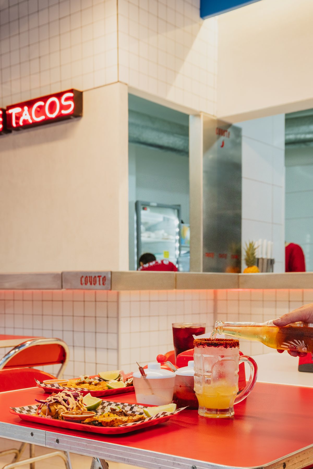 Letrero de tacos y mesa servida en Coyote