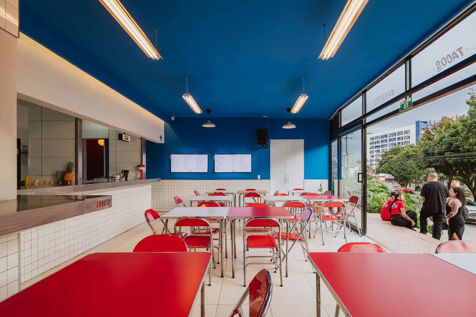Salón de Coyote con techo azul y ventanal a la calle